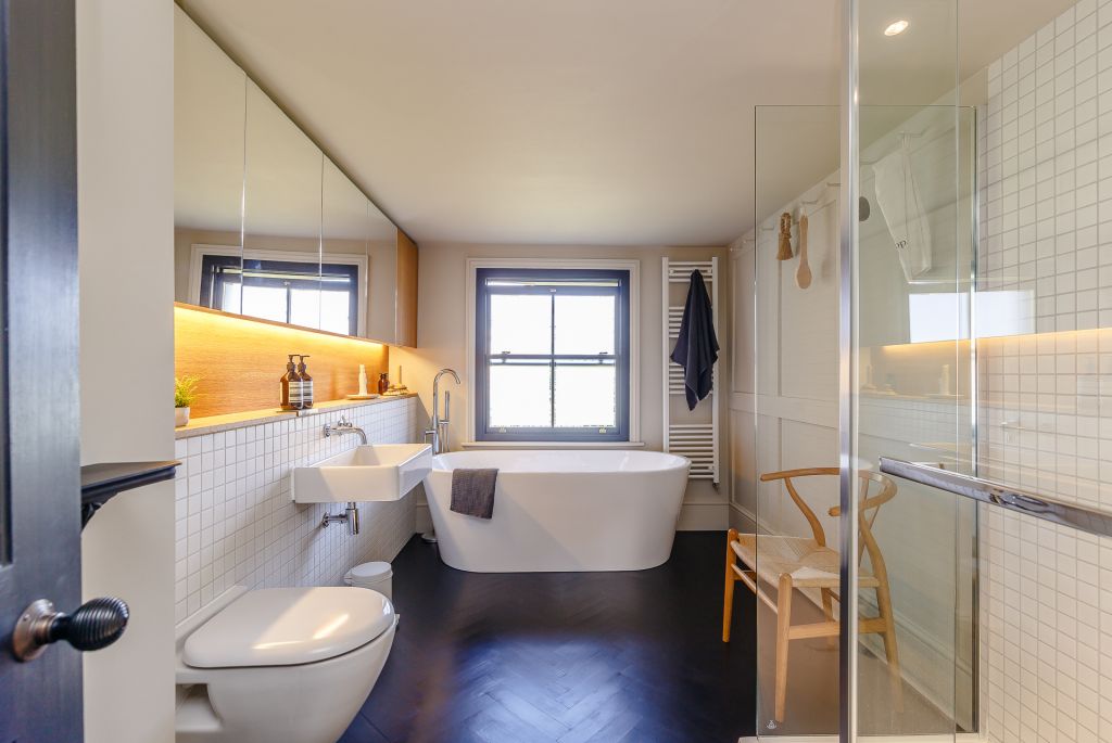 bathroom with mirrored wall cabinets and black parquet flooring